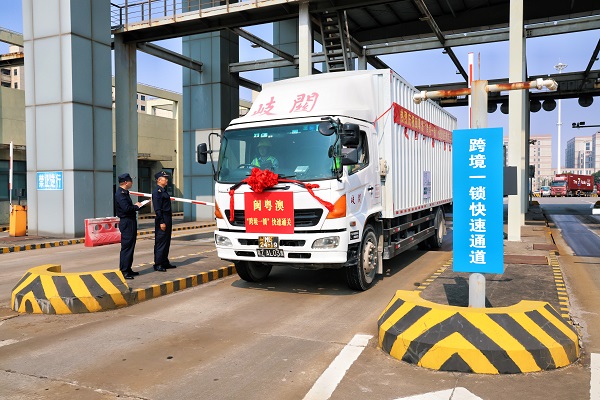 圖為：關員監(jiān)管放行閩粵港澳“跨境一鎖”快速通關車輛